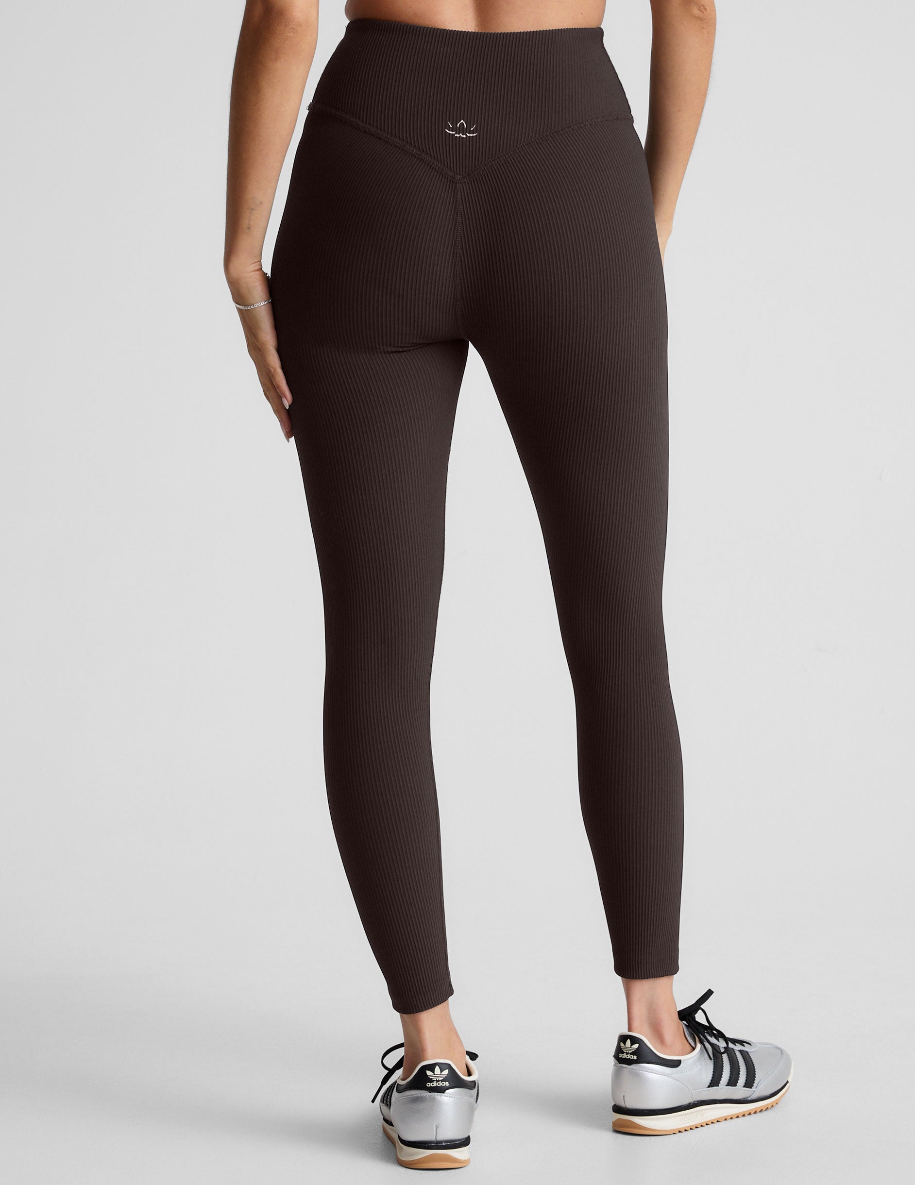 model wearing brown ribbed high-waisted midi length leggings against a plain background.
