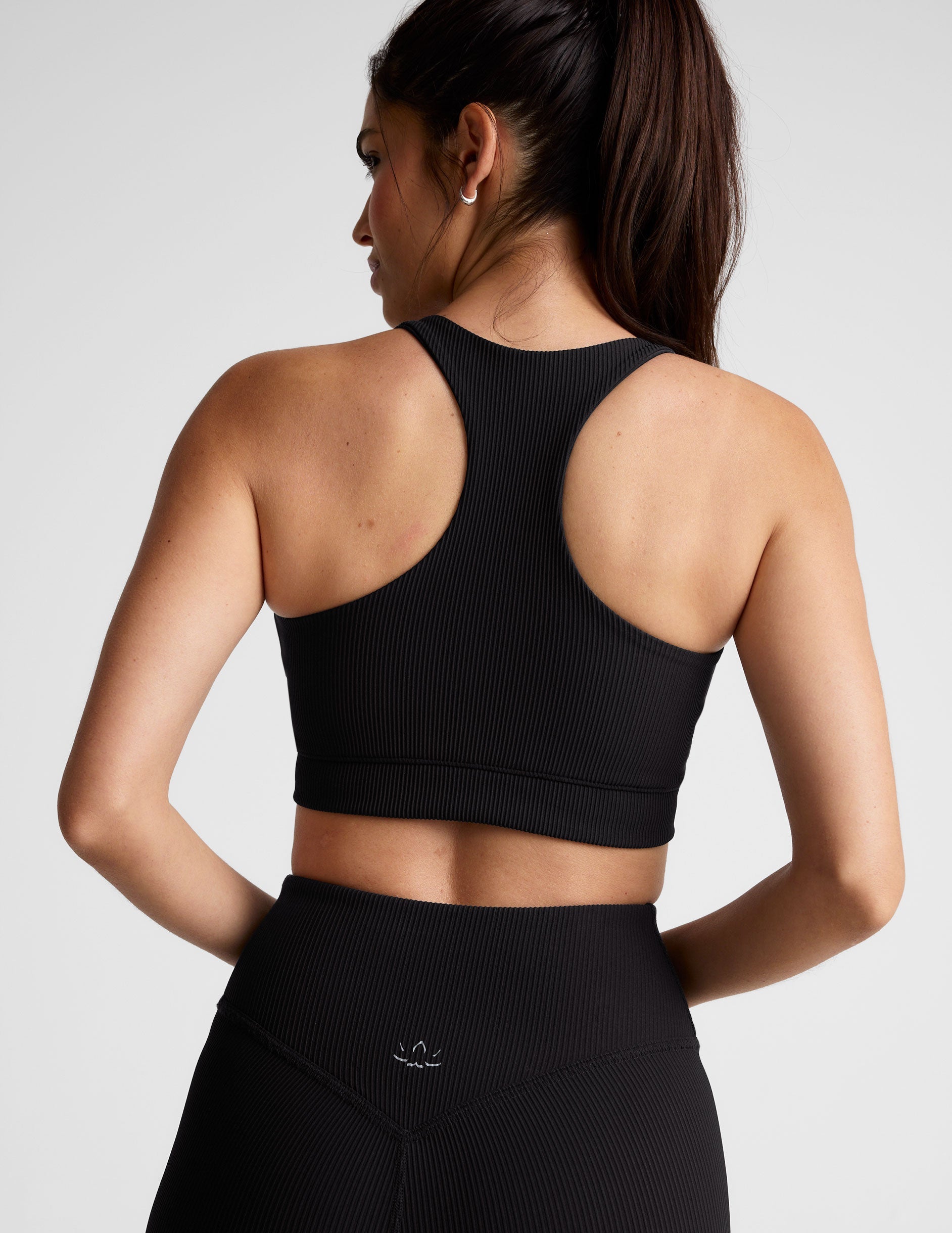 black ribbed racerback bra with overlapping hemband detail​ and a scoop neckline.
