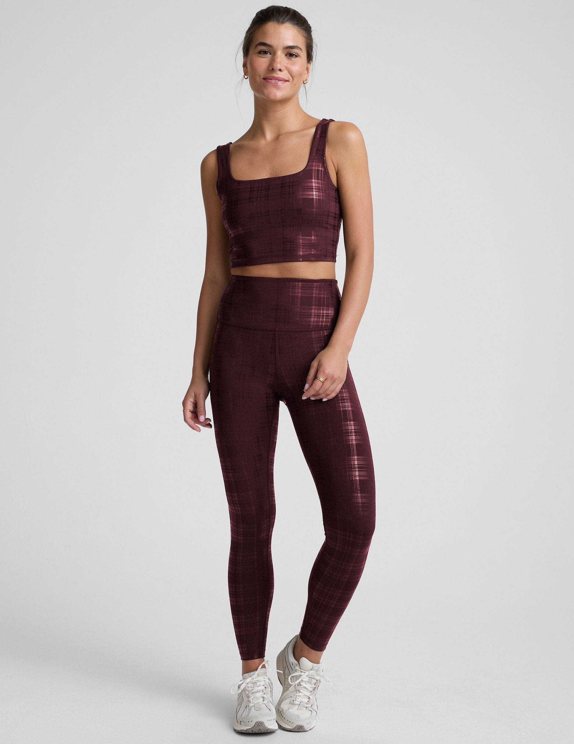 model wearing a red plaid foil printed square neck cropped tank top and matching leggings against a plain background.