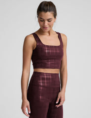 model wearing a red plaid foil printed square neck cropped tank top and matching leggings against a plain background.
