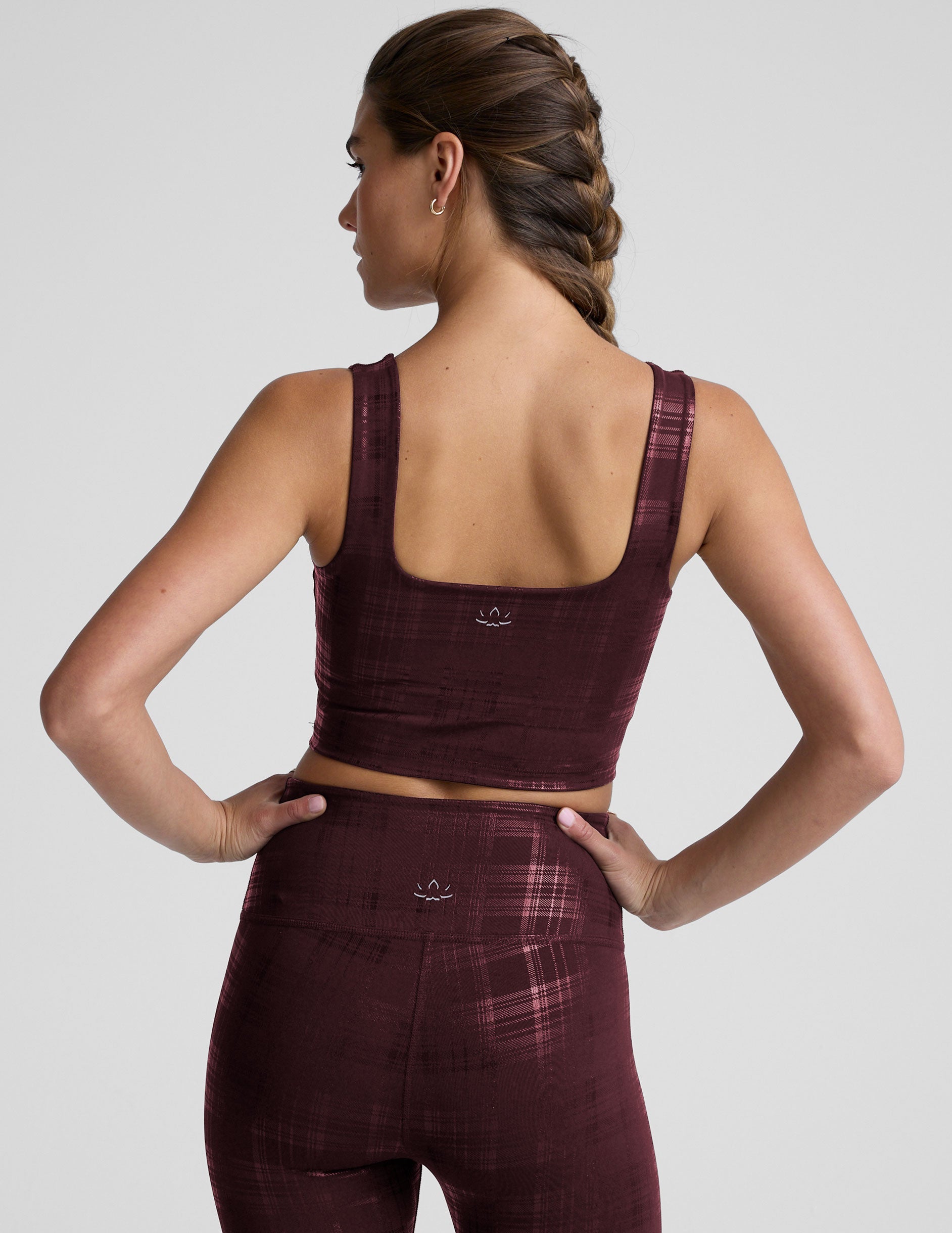 model wearing a red plaid foil printed square neck cropped tank top and matching leggings against a plain background.