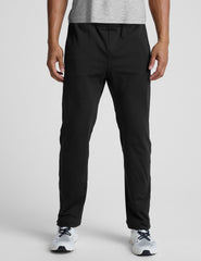 person wearing black pants and white sneakers on a light gray background
