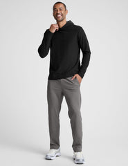 man wearing a black hoodie and gray pants on a white background.