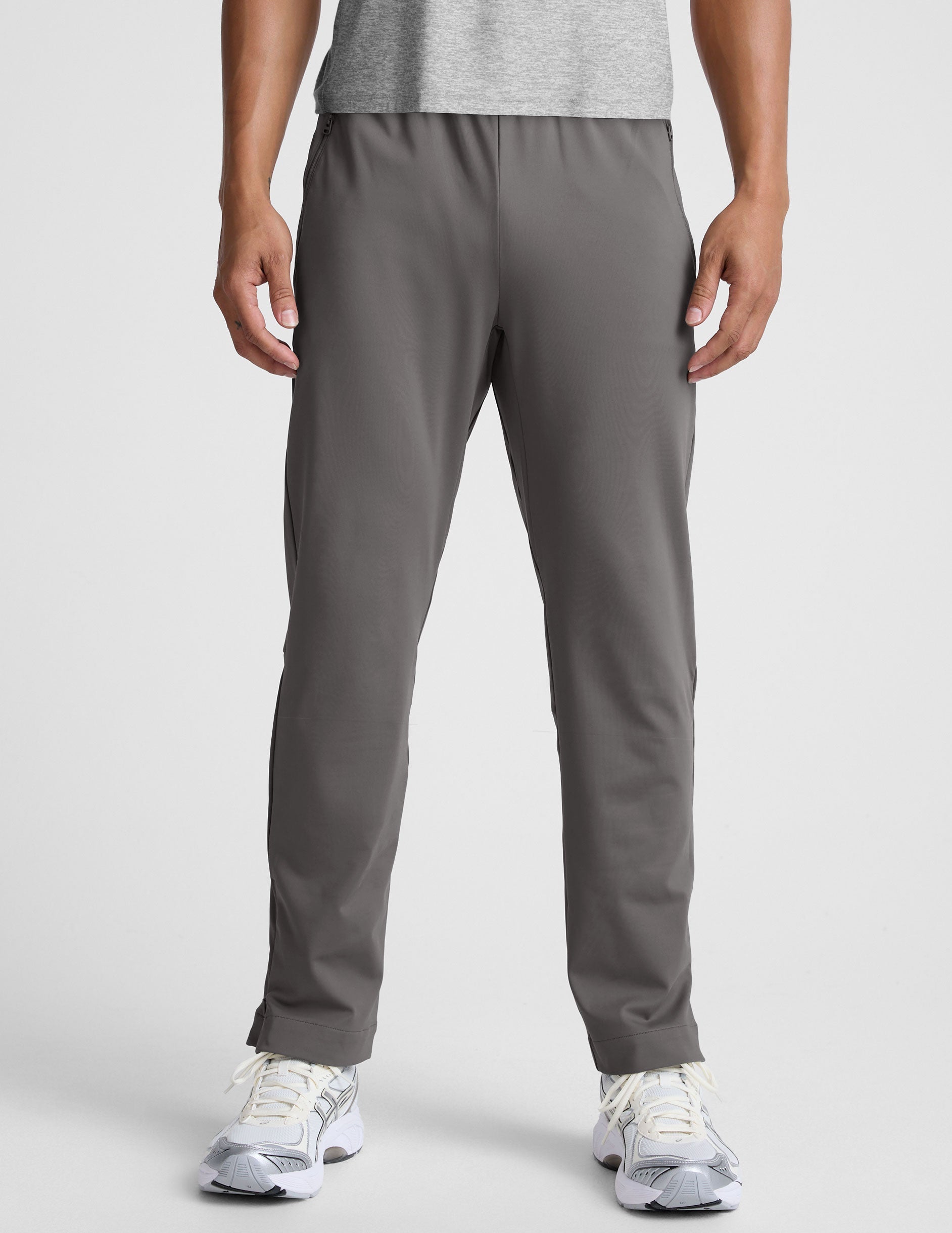 man wearing a gray shirt and gray pants on a white background.