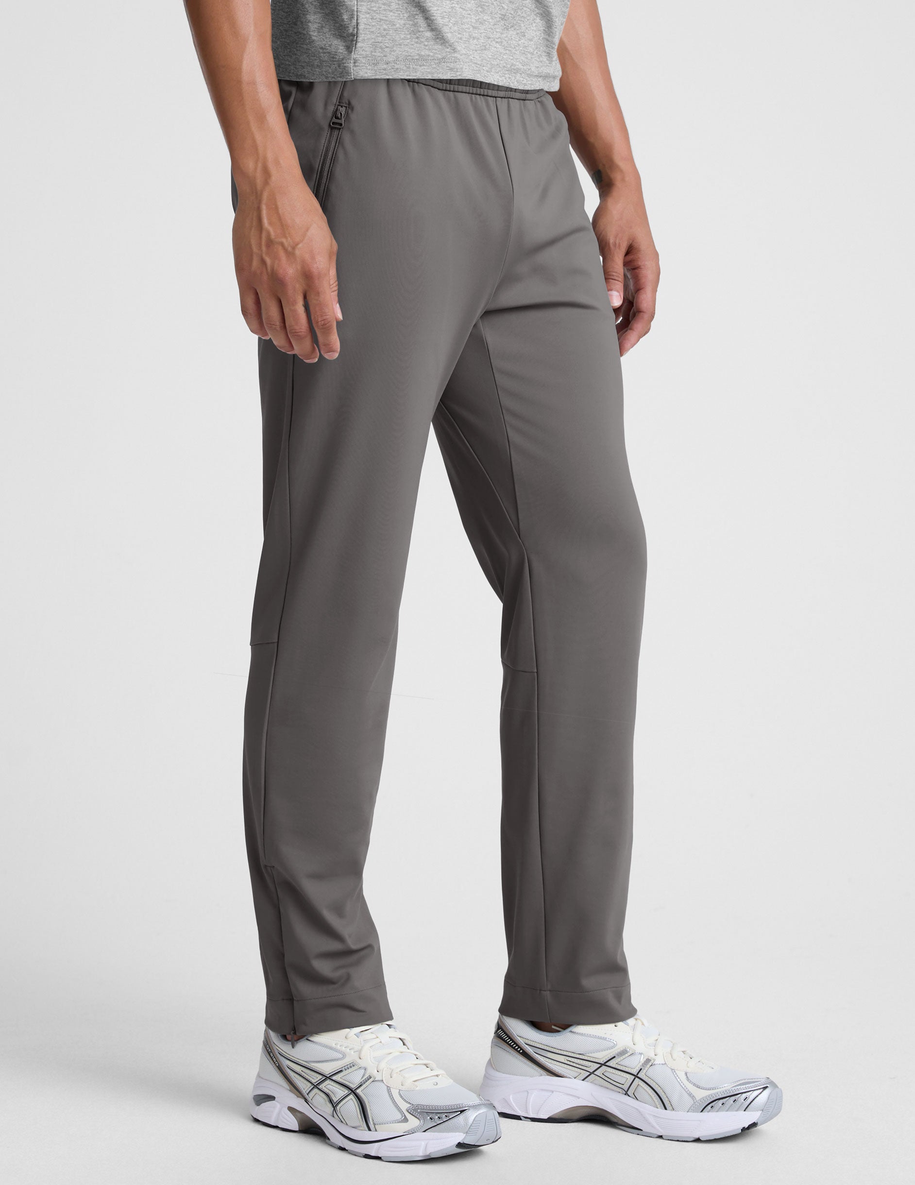 man wearing a gray shirt and gray pants on a white background.