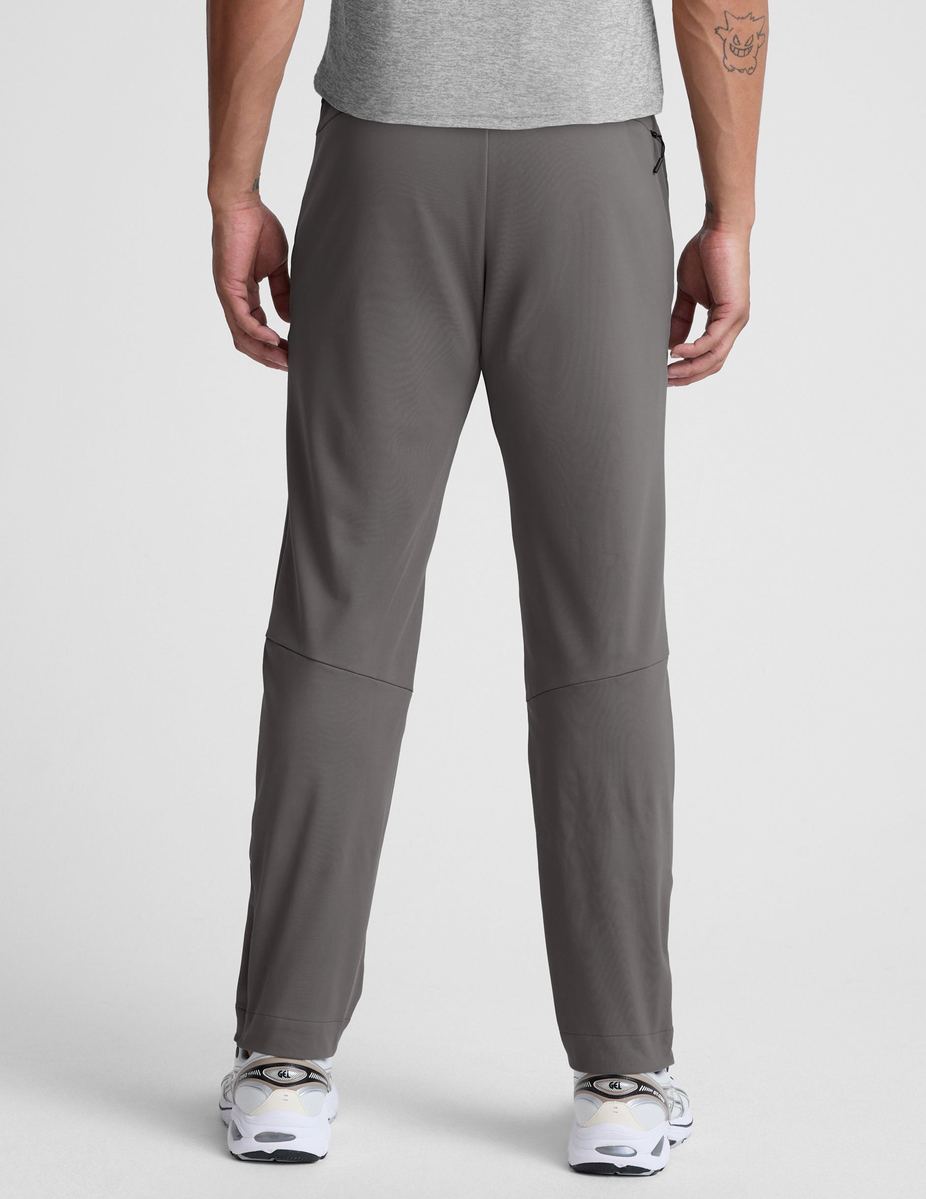 man wearing a gray shirt and gray pants on a white background.