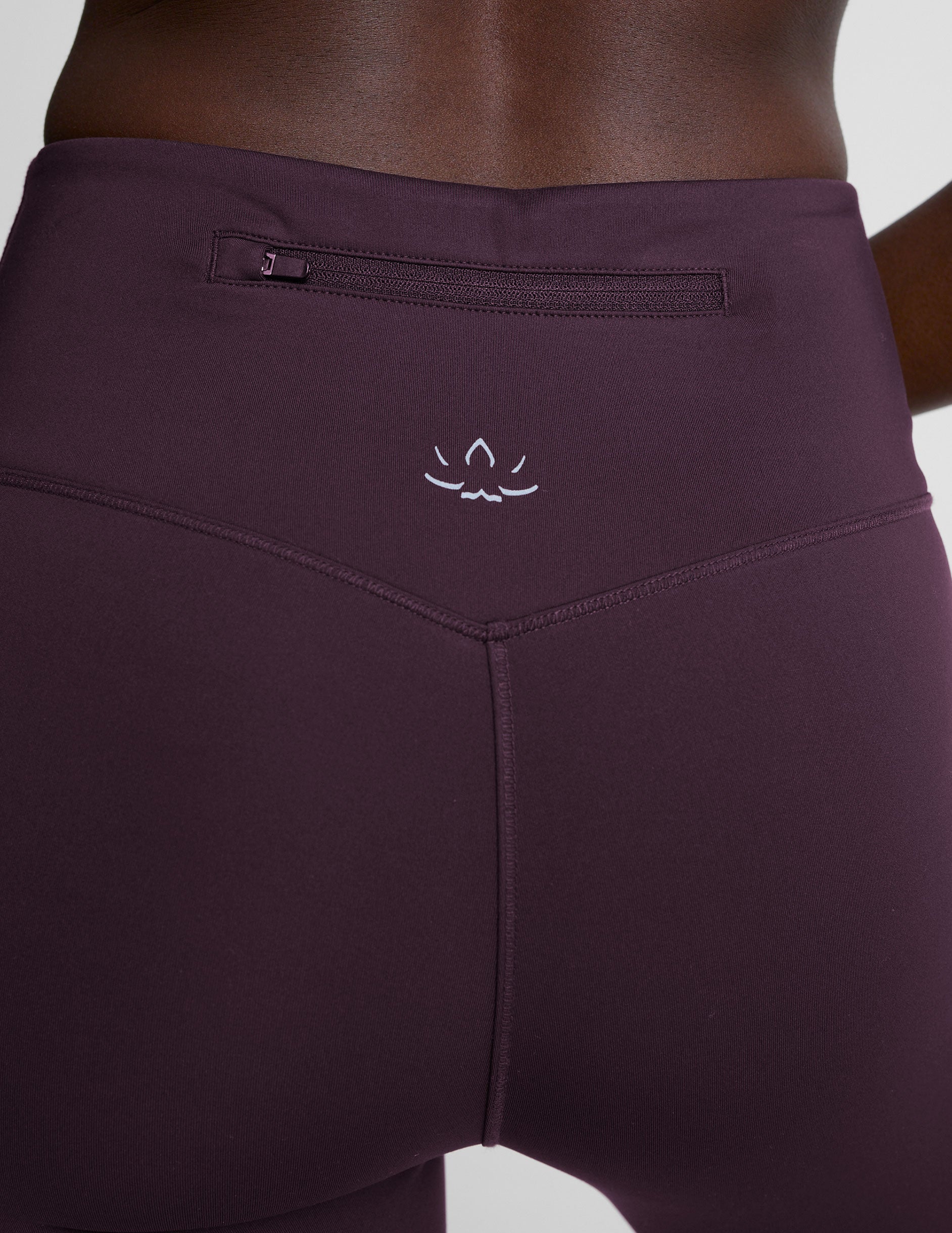 person wearing dark purple pants on a light gray background.