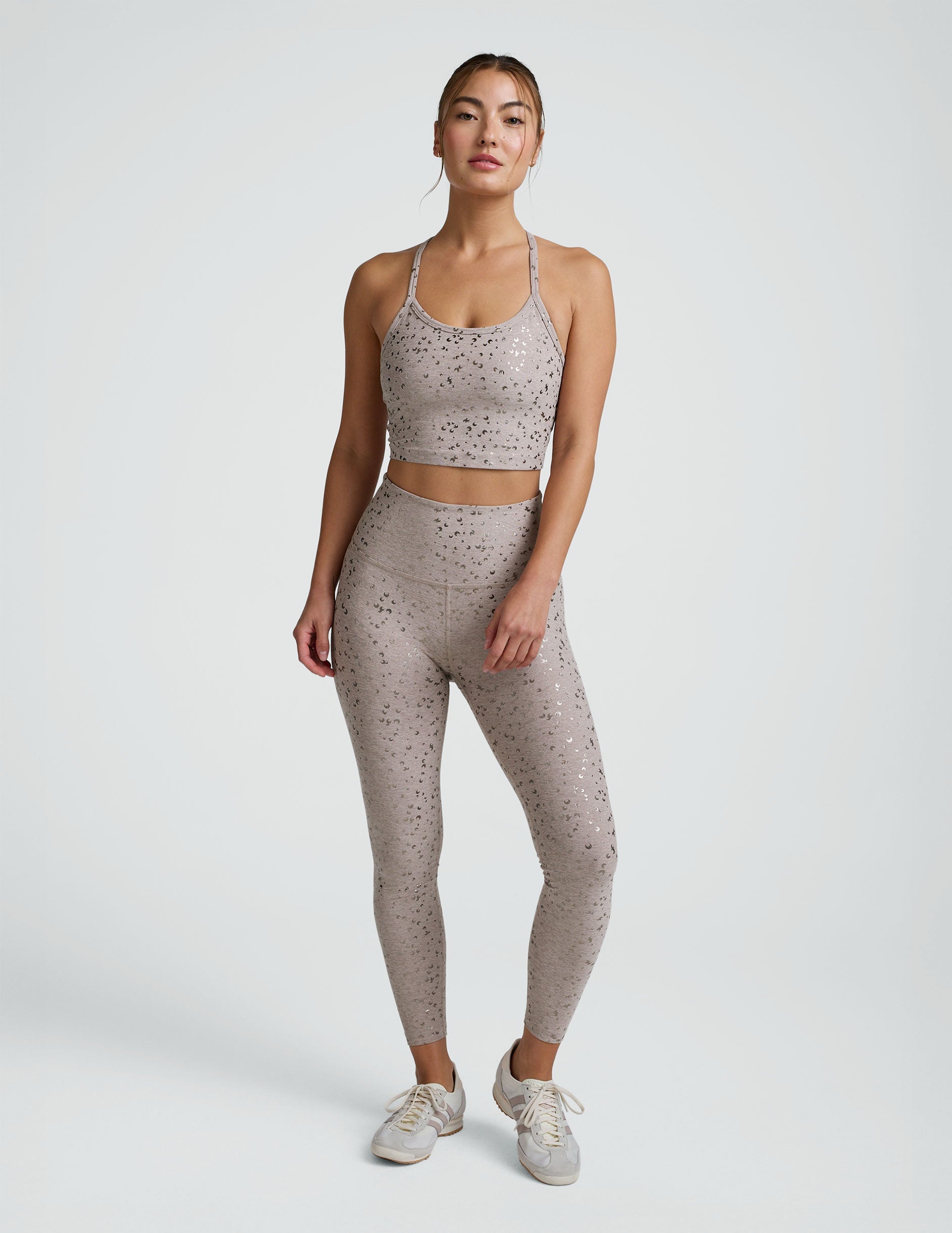 woman in pink mini moon printed cropped tank and leggings against a plain background.