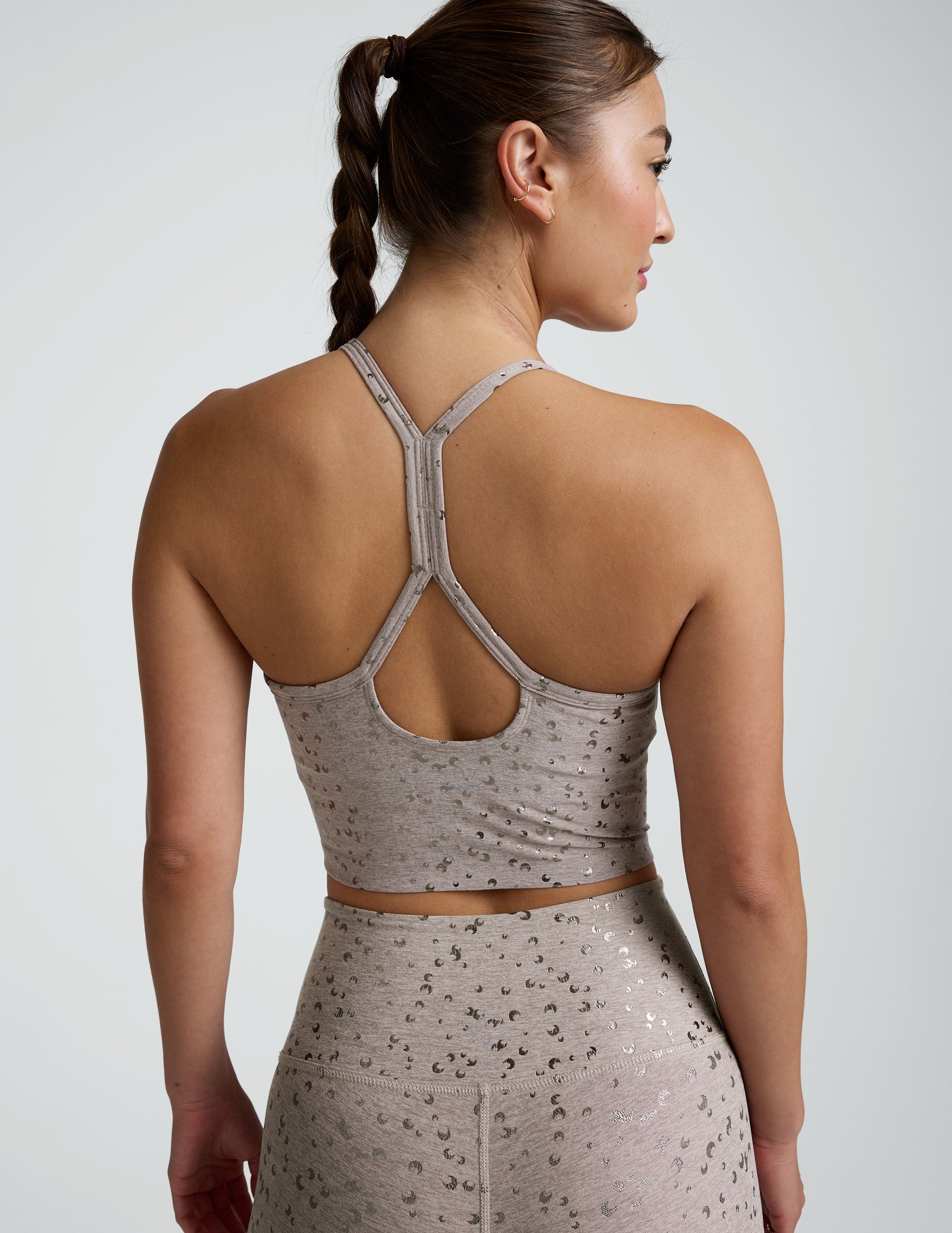 woman in pink mini moon printed cropped tank and leggings against a plain background.