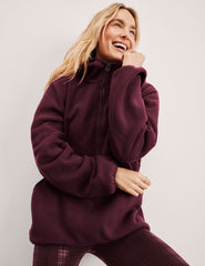 red fleece quarter zip jacket with a kangaroo pocket.