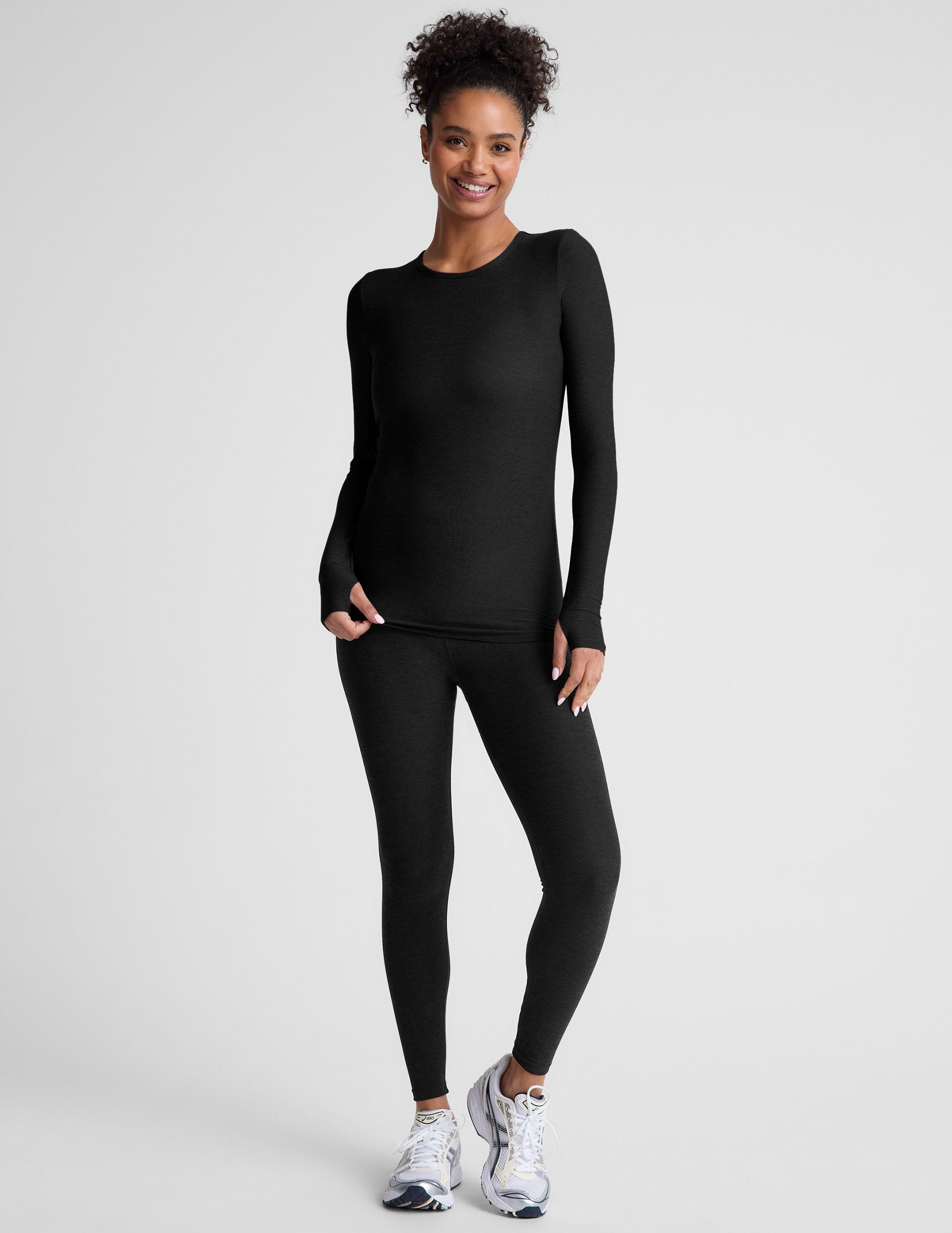 black crew neck long sleeve top with thumb holes.
