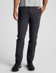male model wearing a grey t-shirt and chino pants on a light background.
