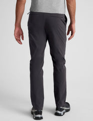 male model wearing a grey t-shirt and chino pants on a light background.