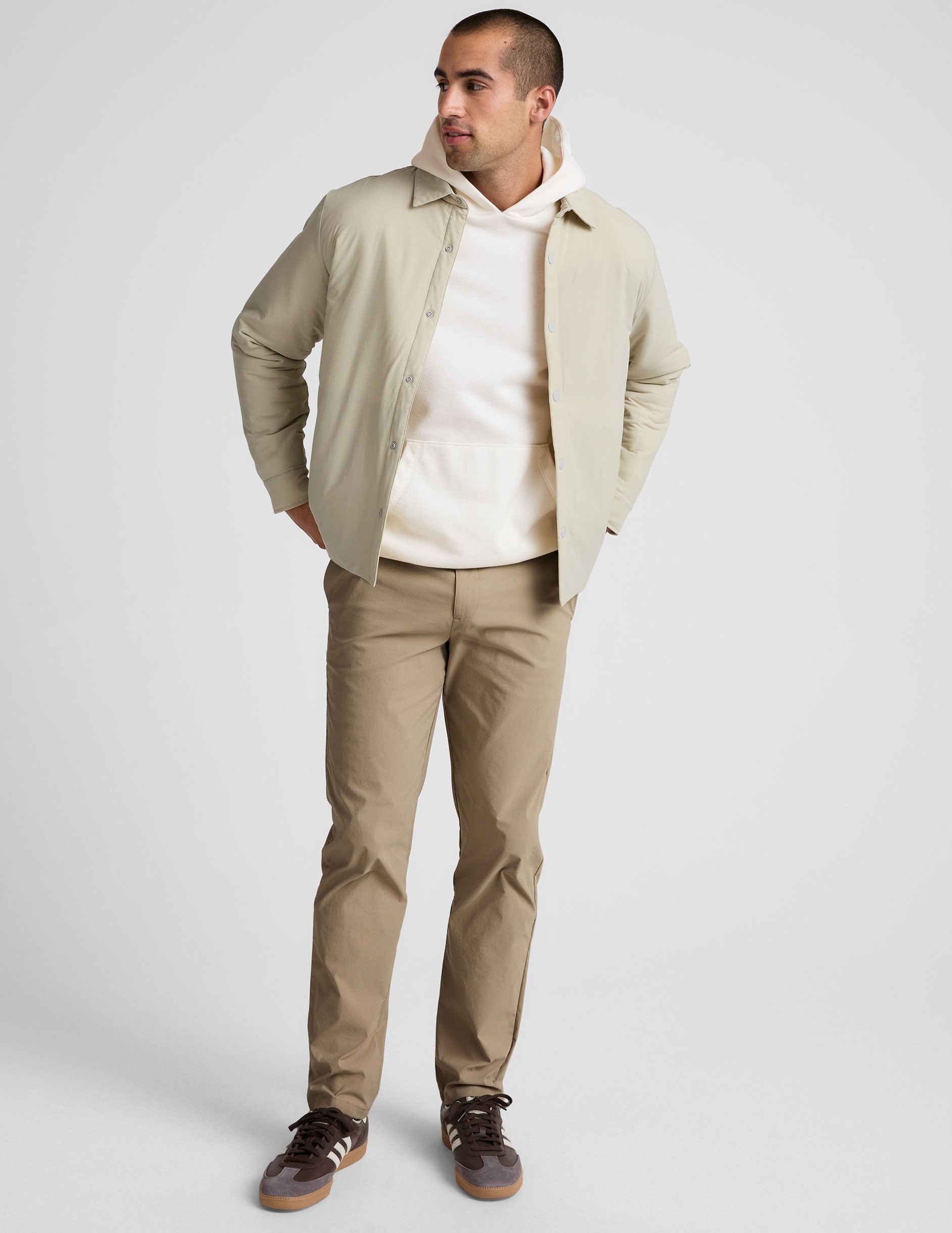 man wearing beige chino pants with side pockets on a plain background.