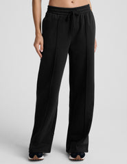 model wearing a gray tank top and black wide-leg pants on a plain background.