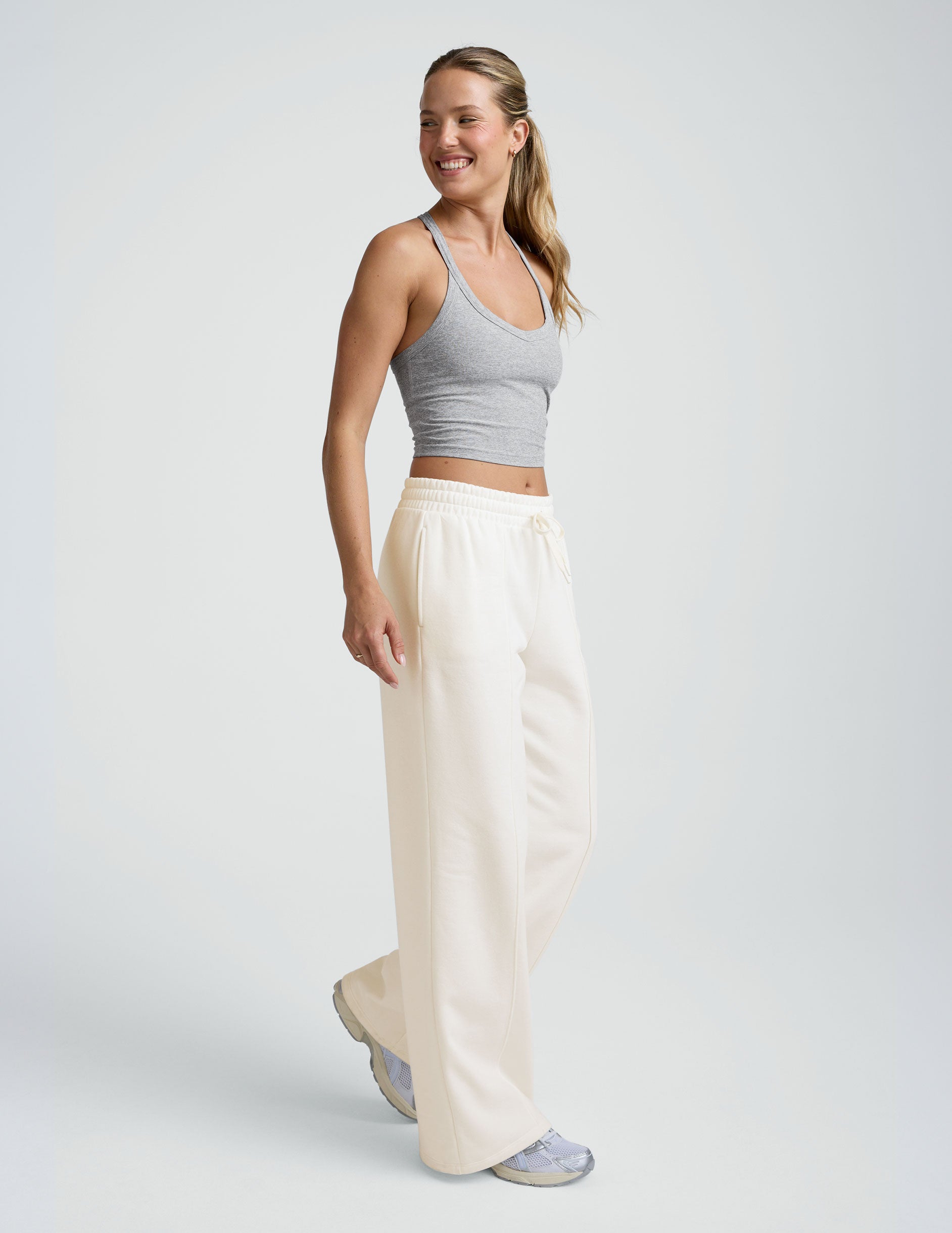 model wearing a grey tank and white fleece wide leg pants against a plain background.