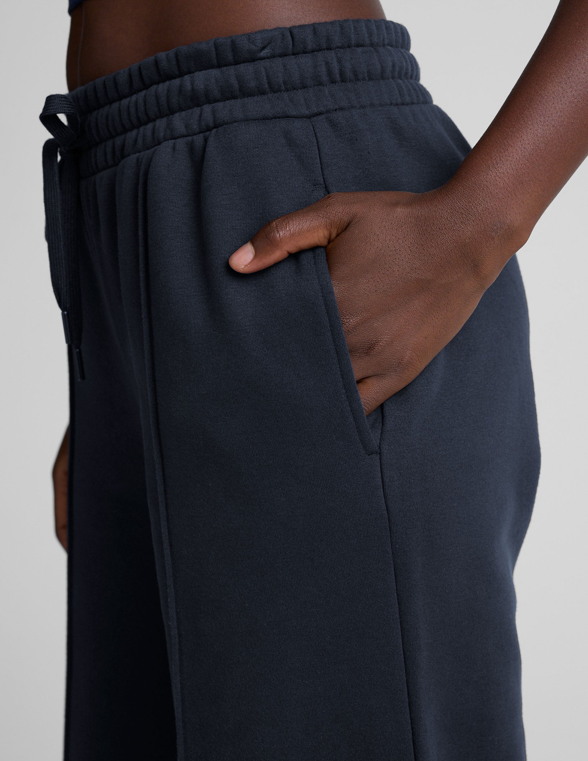 model is wearing blue fleece wide leg pants against a plain background.