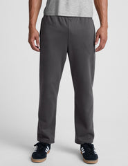 man wearing a gray shirt and gray straight leg sweatpants on a plain background.