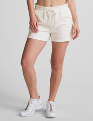 white sweat shorts with pockets and a drawstring at waistband.