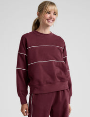 red fleece crewneck sweater with white contrast piping trim at chest and sleeves.
