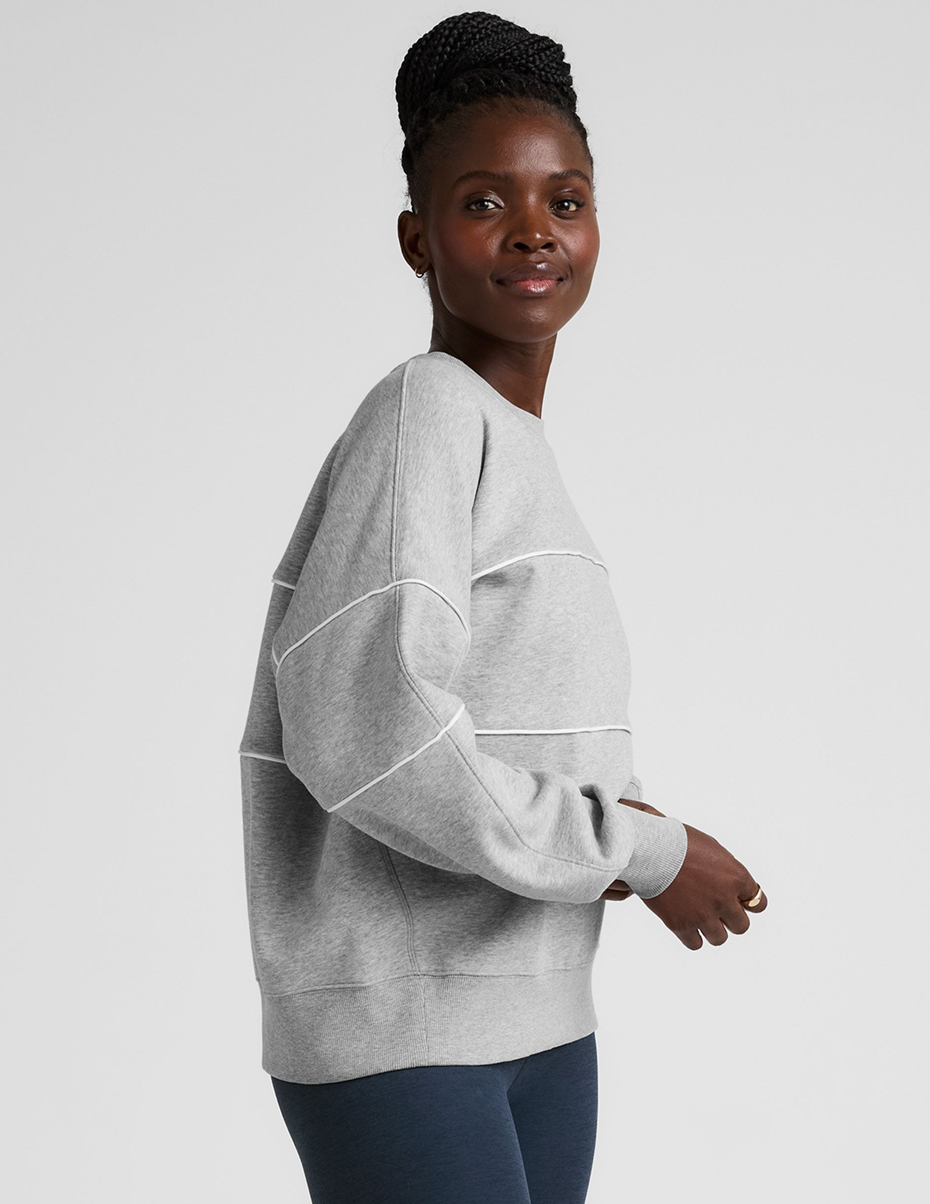 gray fleece crewneck sweater with white contrast piping trim at chest and sleeves.