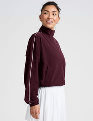 red zip-up jacket with white piping and pockets.