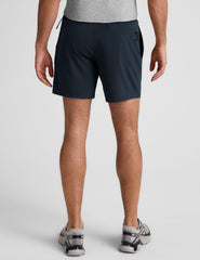 man wearing a grey t-shirt and navy blue lined shorts set on a plain background.