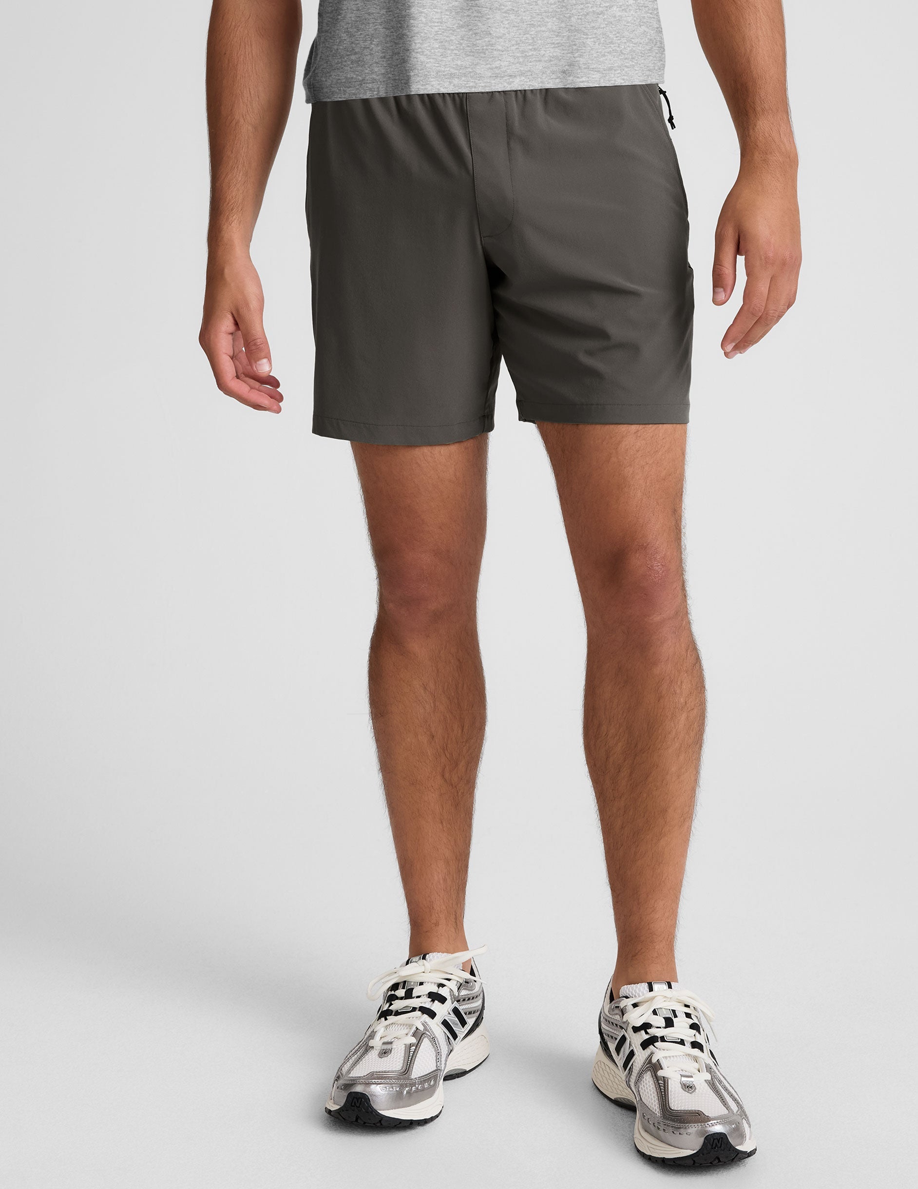 man wearing a gray t-shirt and graphite shorts on a white background.