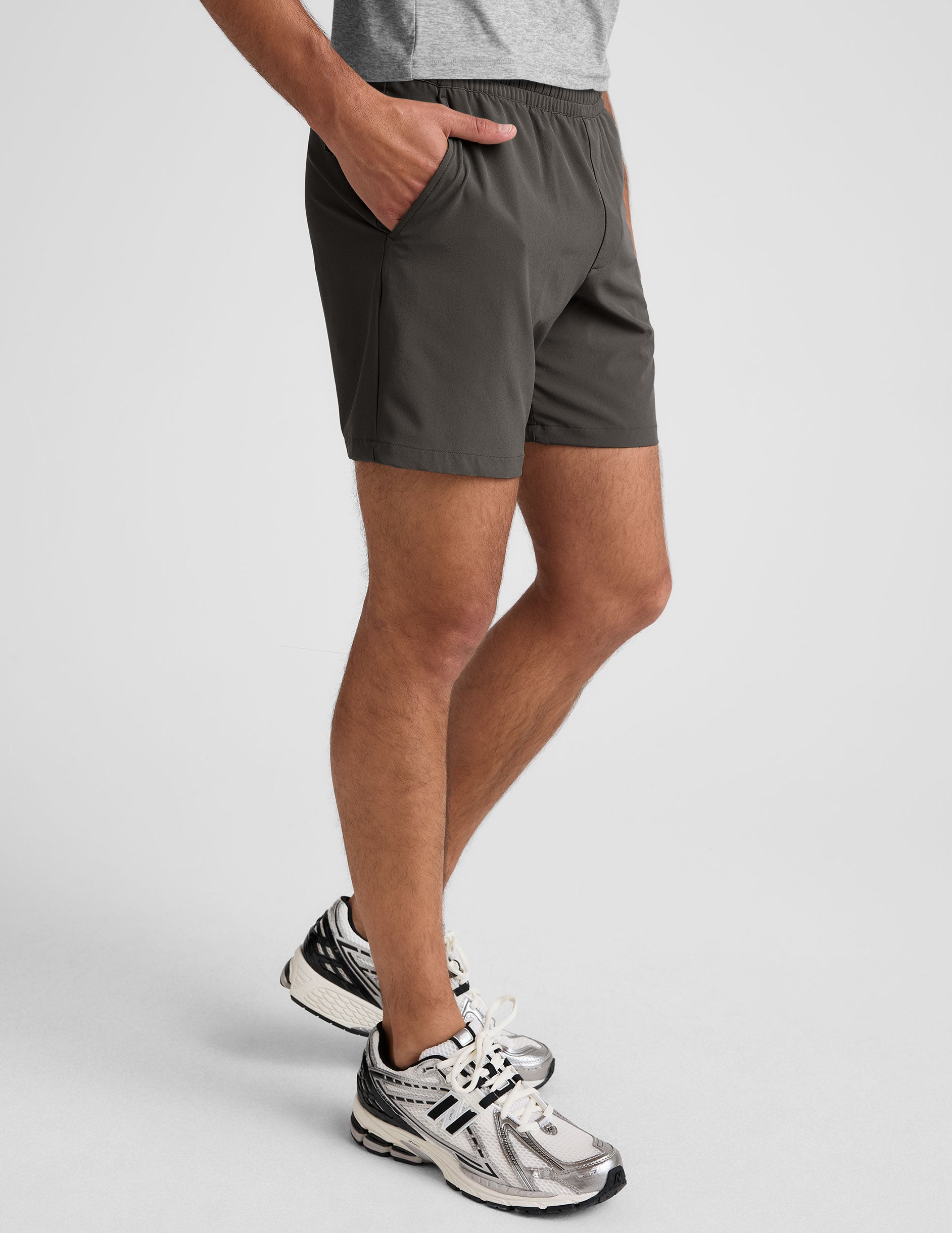 man wearing a gray t-shirt and graphite shorts on a white background.