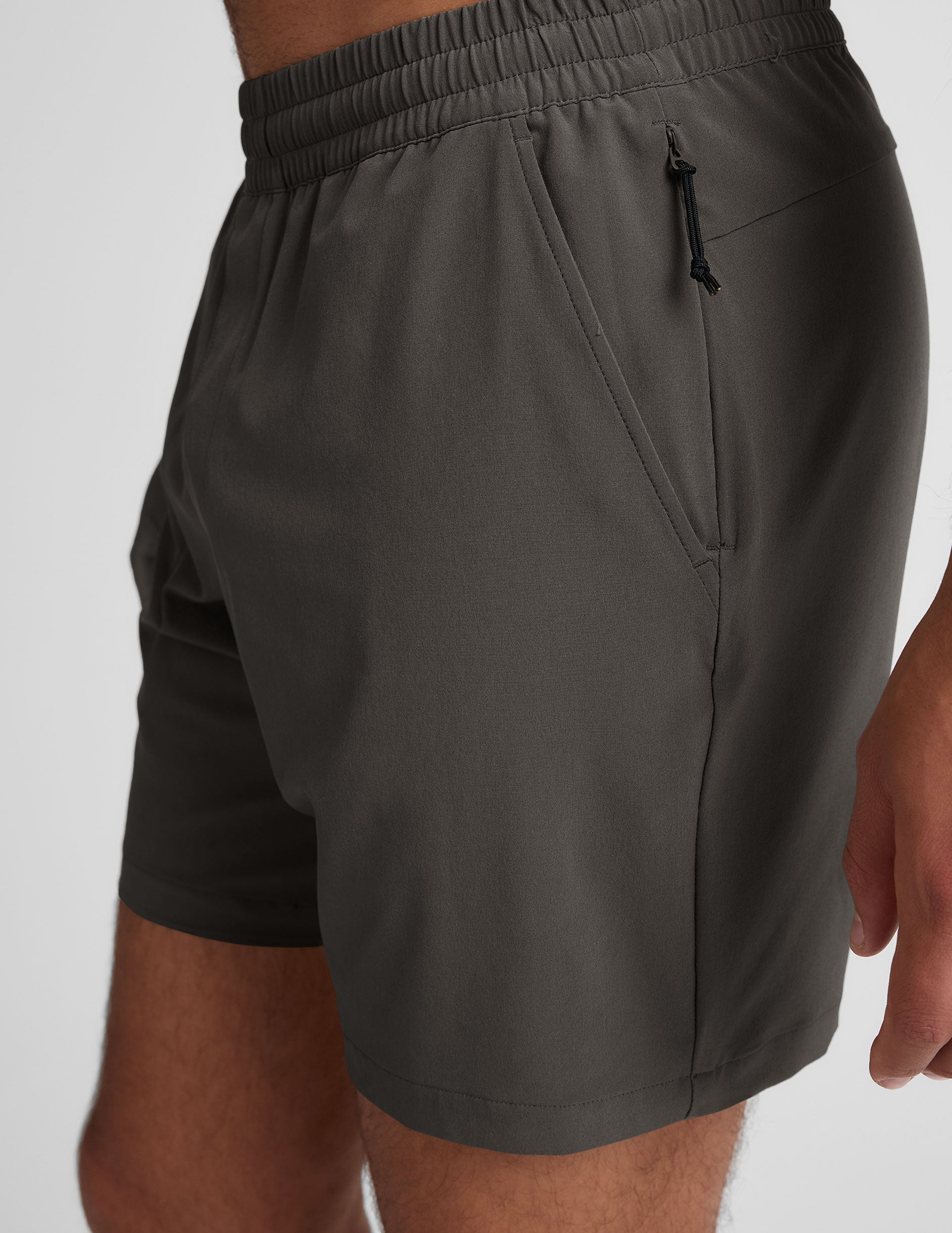 man wearing a gray t-shirt and graphite shorts on a white background.
