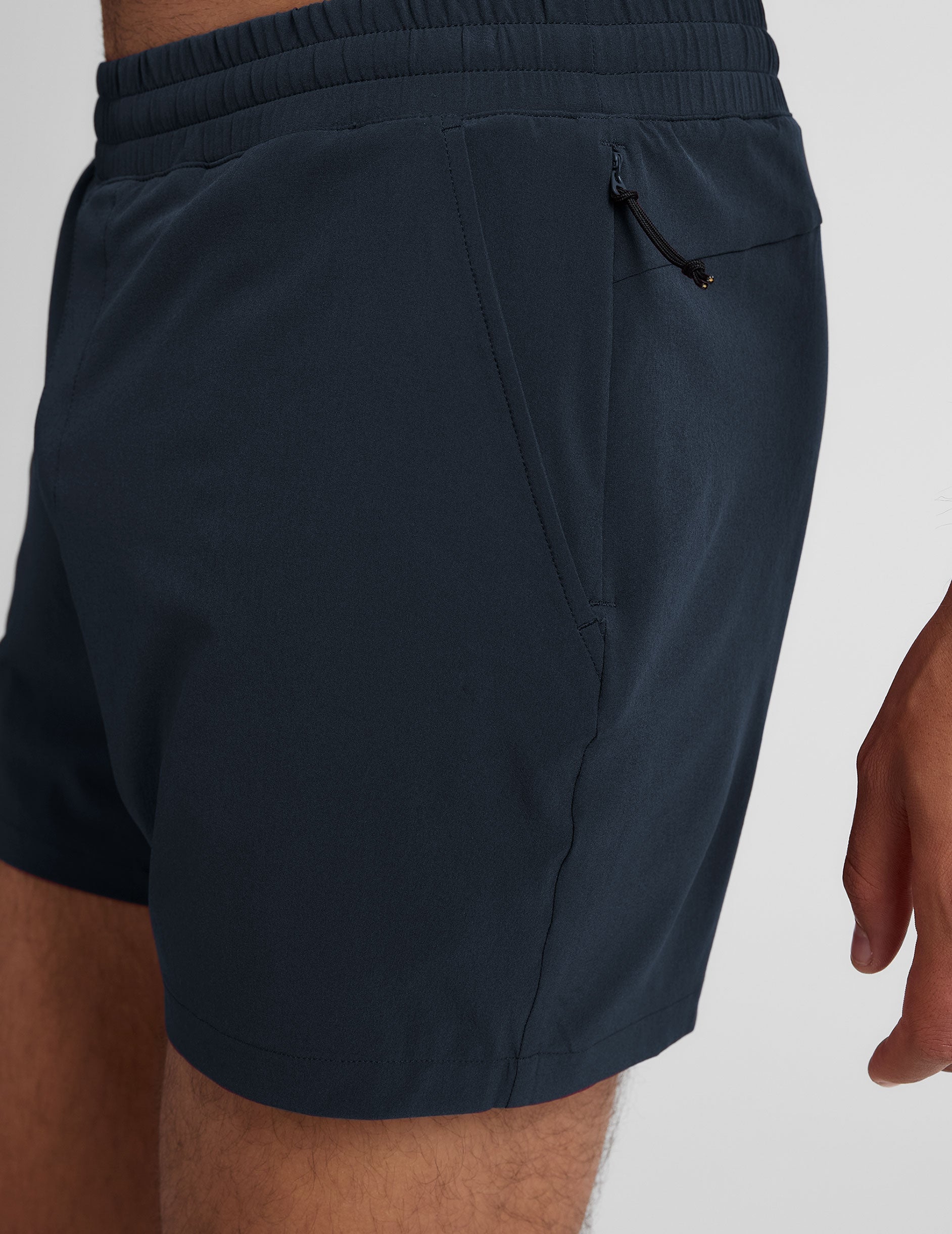 navy t-shirt and navy 5" shorts on a plain background. 