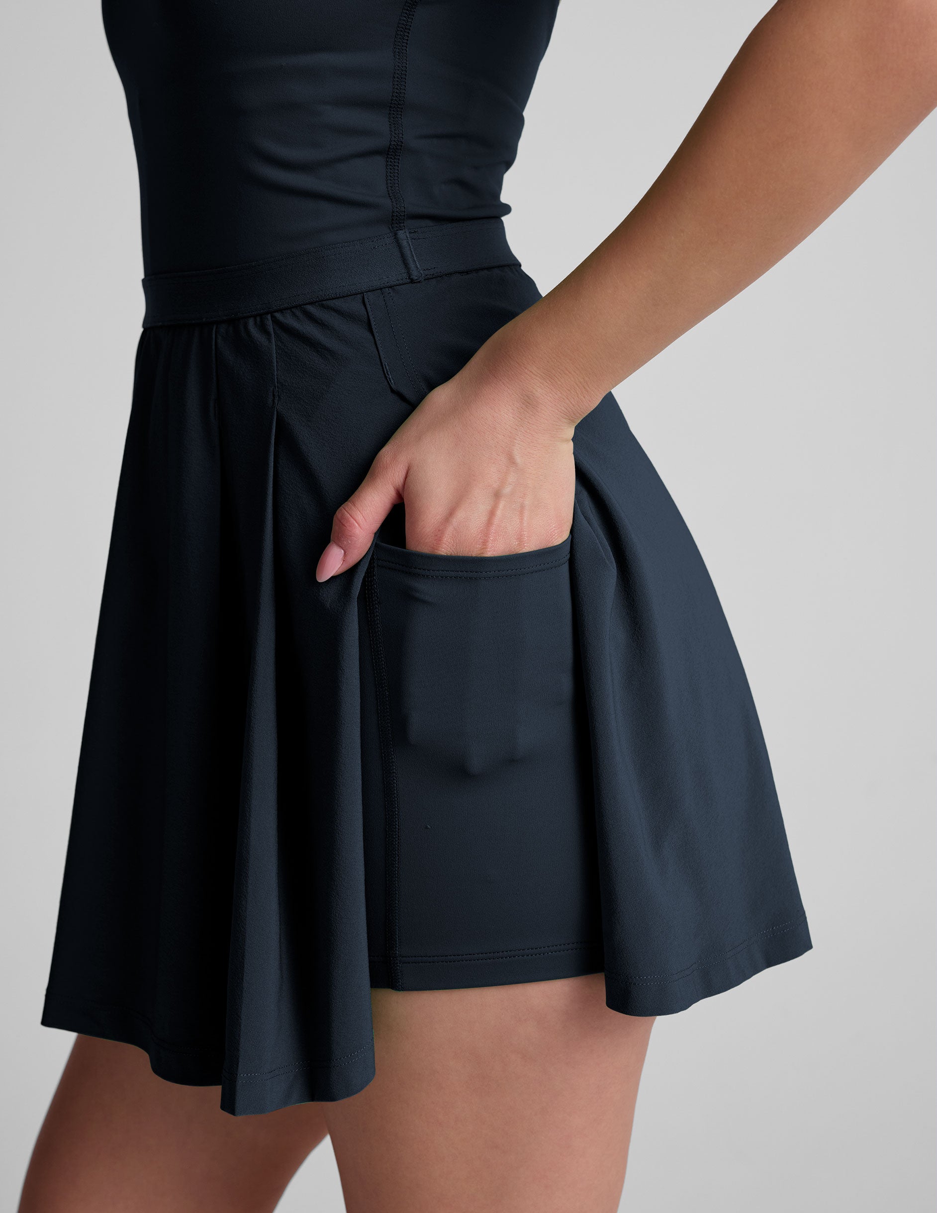 blue mini athletic dress with an open back detail and built-in shorts with pockets.