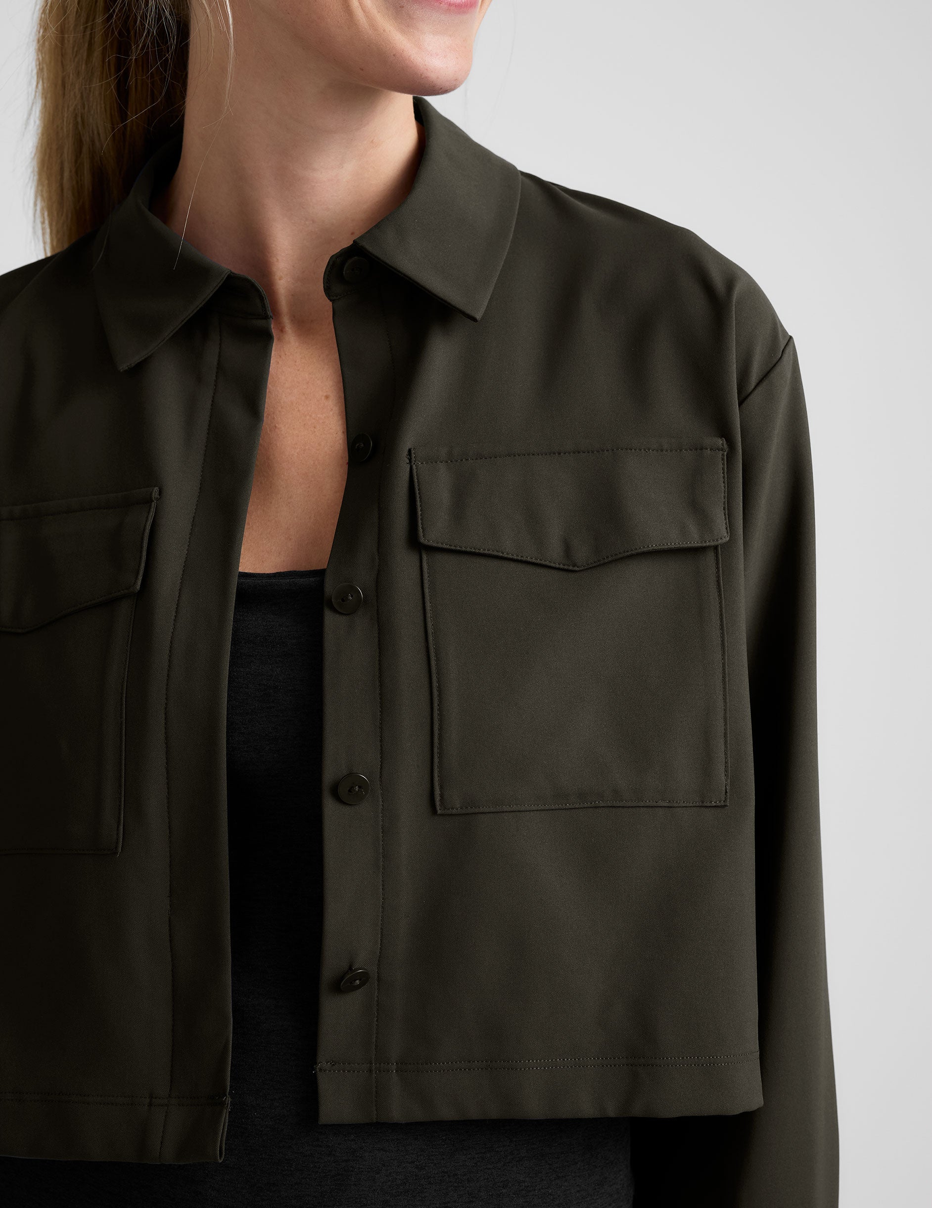 green cropped jacket with front chest cargo pockets and a collar at neckline.