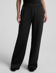 model is wearing a black sleeveless top and black spacer style pants with pockets against a plain background.