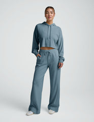 Person wearing a blue ribbed hoodie and pants on a white background.