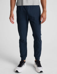 grey t-shirt and navy jogger pants on a plain background.