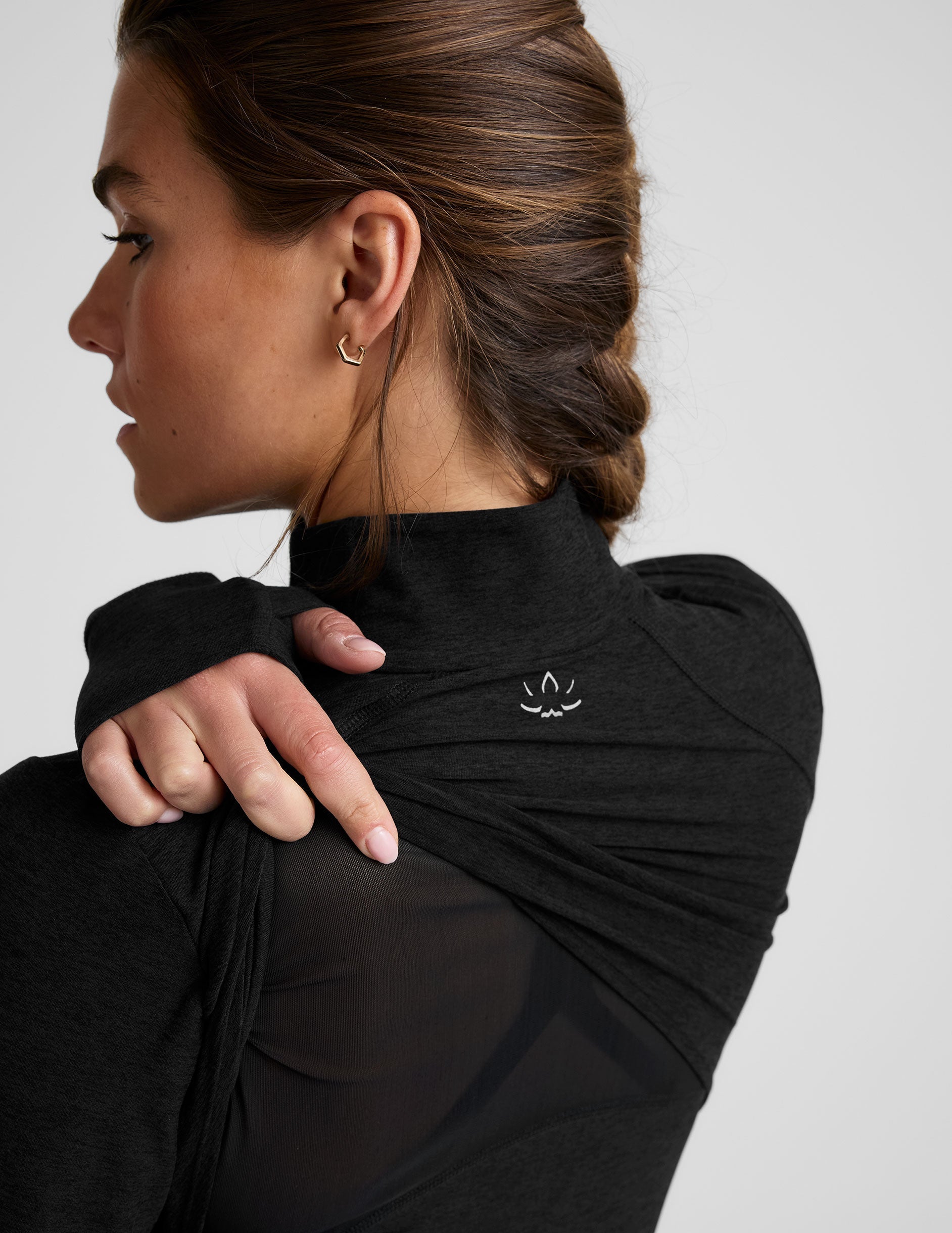 black zip-up mock neck jacket with pockets and thumbholes.