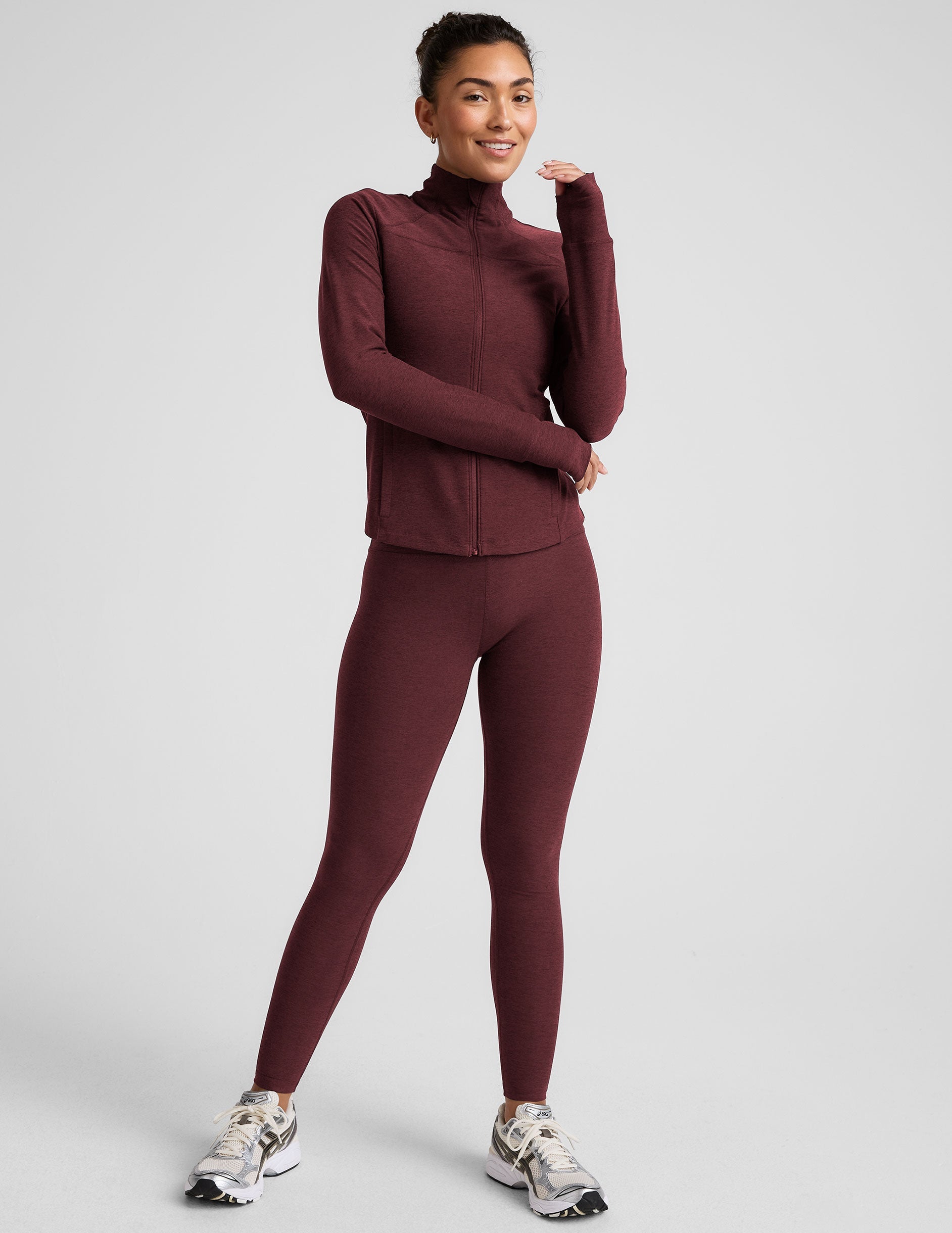 red zip-up mock neck jacket with pockets and thumbholes.