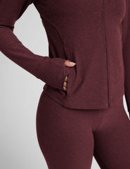 red zip-up mock neck jacket with pockets and thumbholes.