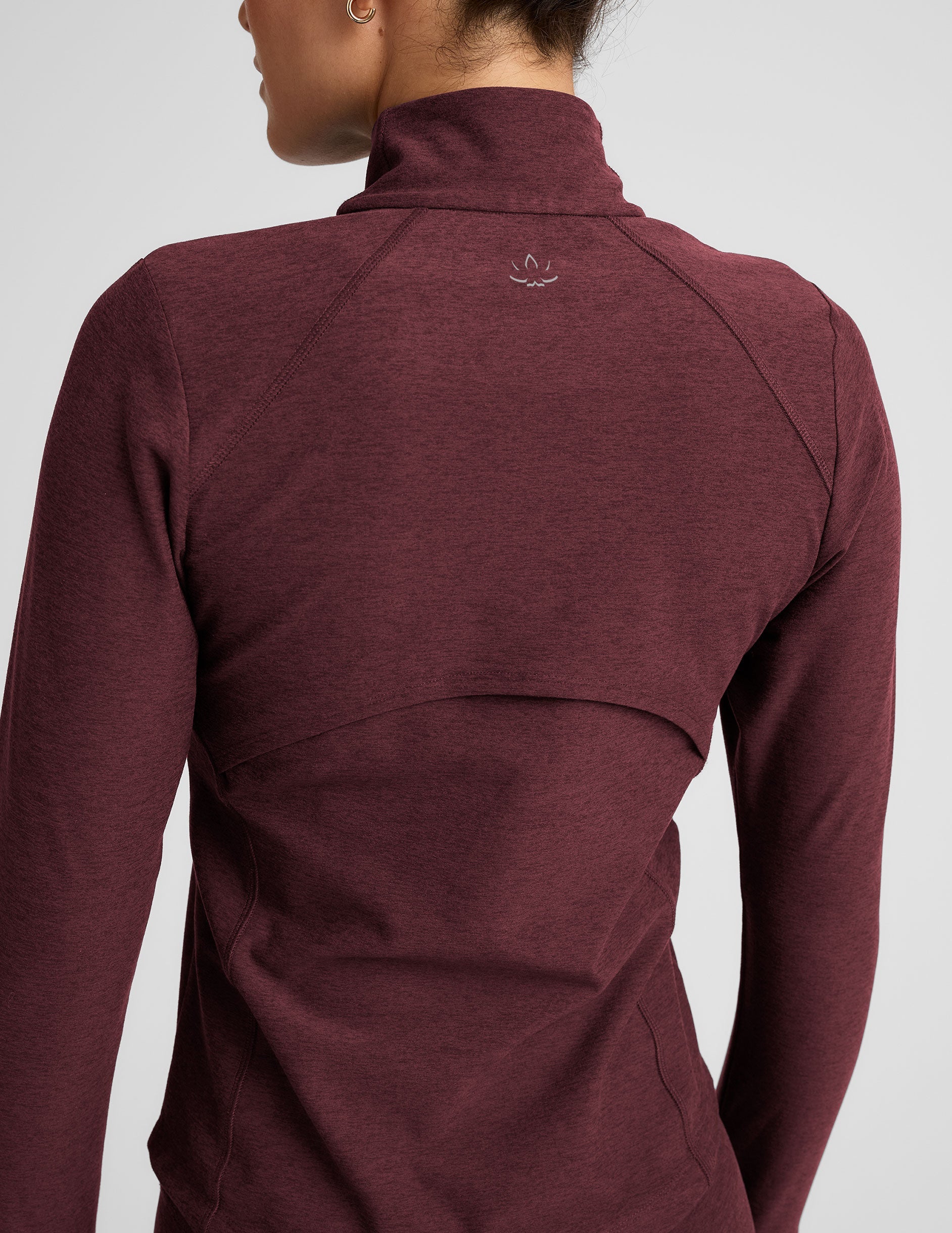 red zip-up mock neck jacket with pockets and thumbholes.