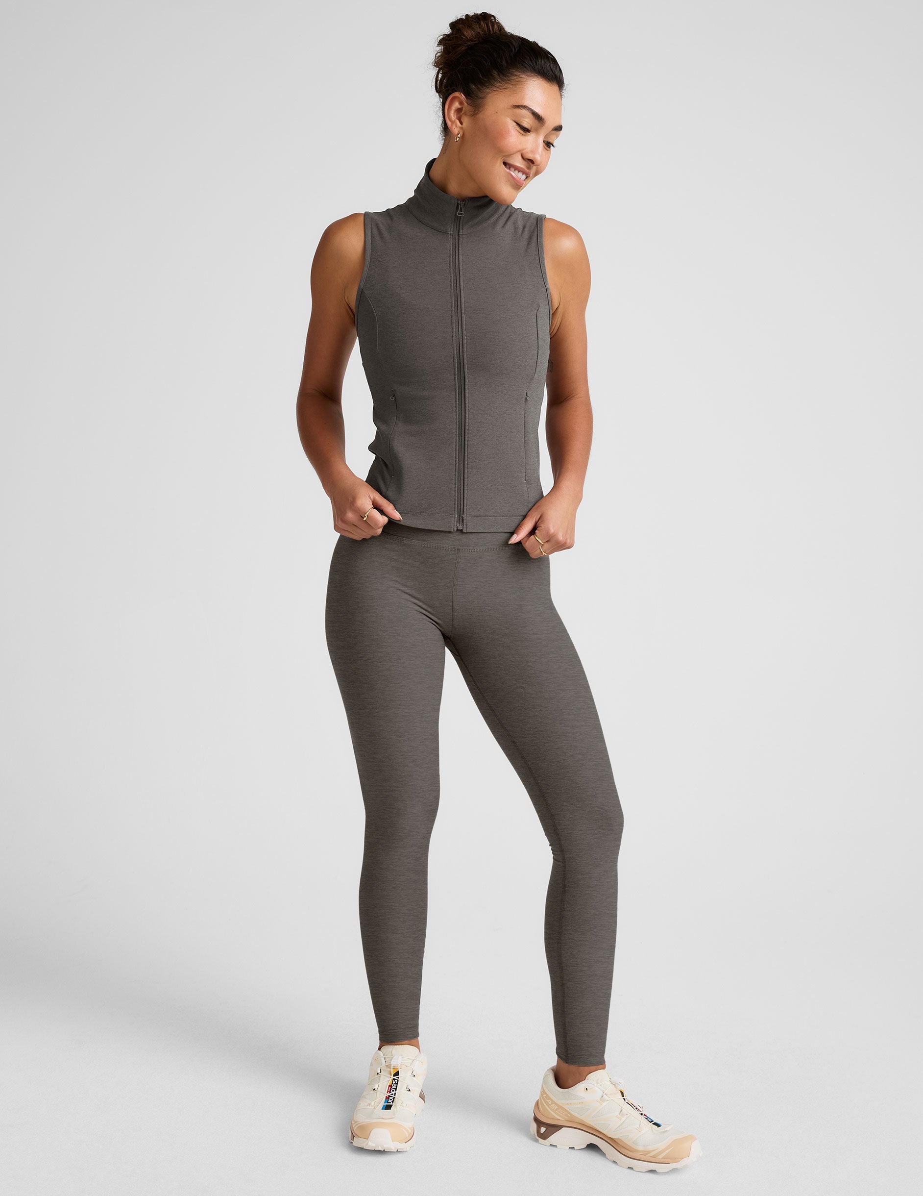 grey zip-up vest with mesh detail on upper back and pockets.