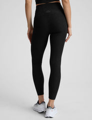 model wearing black high-waisted midi leggings on a white background.