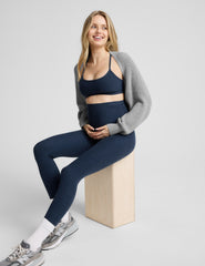pregnant woman wearing a blue racerback bra and blue maternity midi leggings.