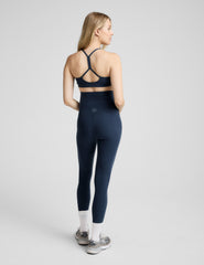 pregnant woman wearing a blue racerback bra and blue maternity midi leggings.