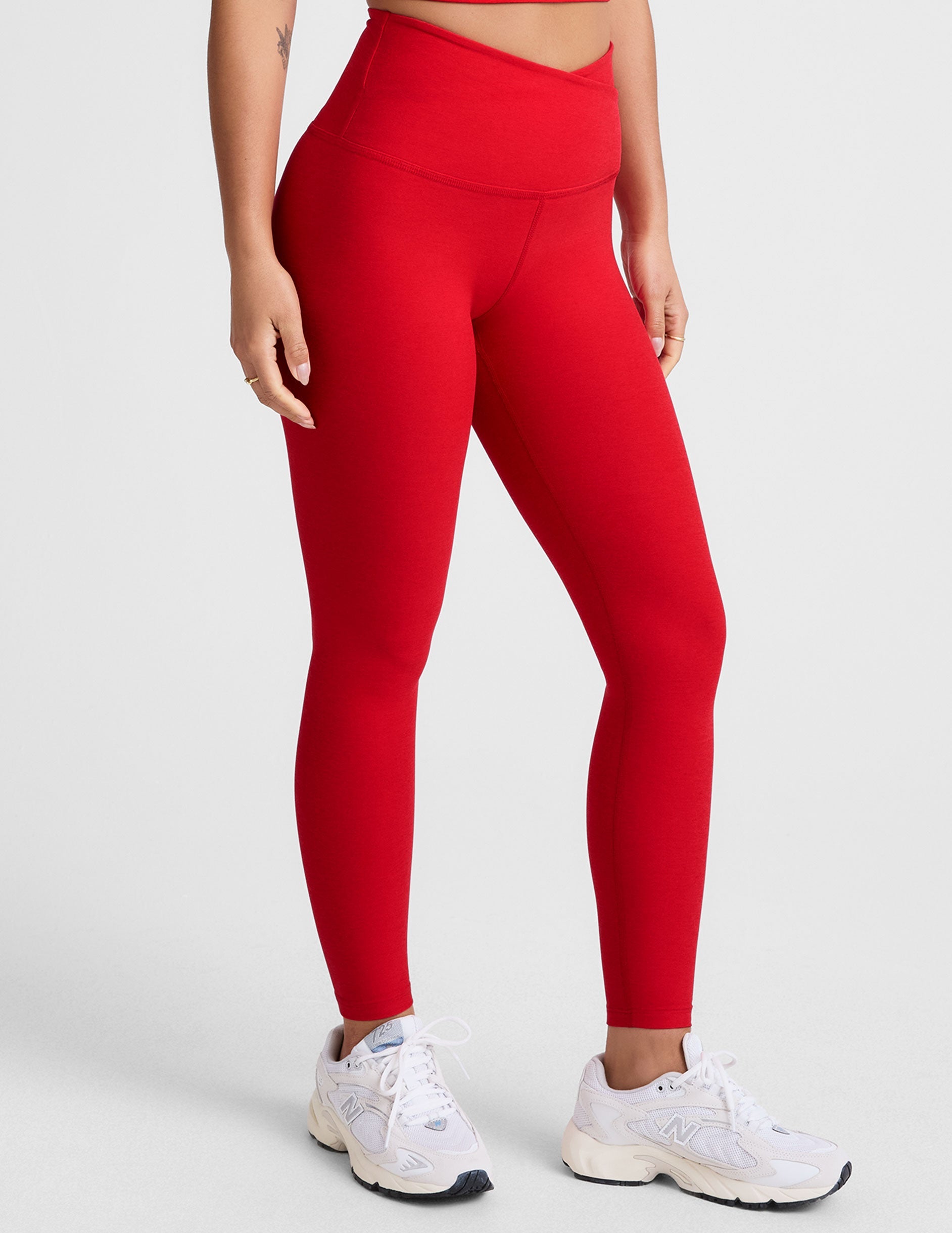 red high-waisted midi legging with criss cross front detail.