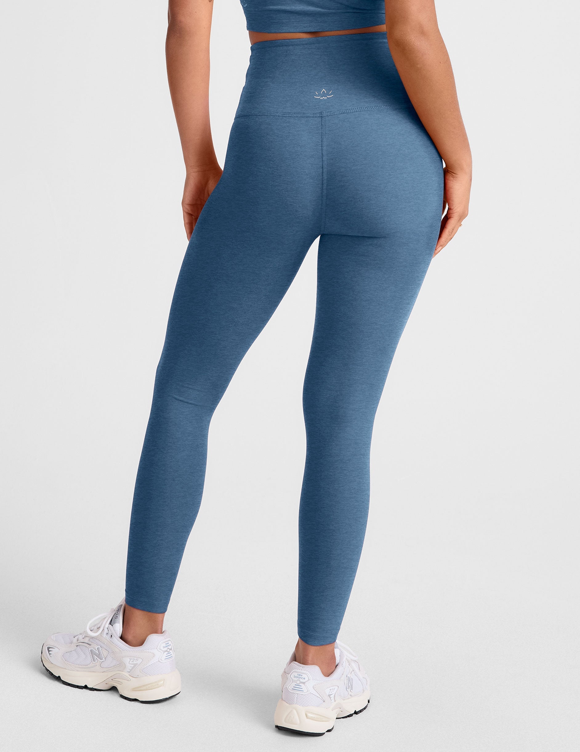 blue high-waisted midi length leggings with an overlapping front v waistband.