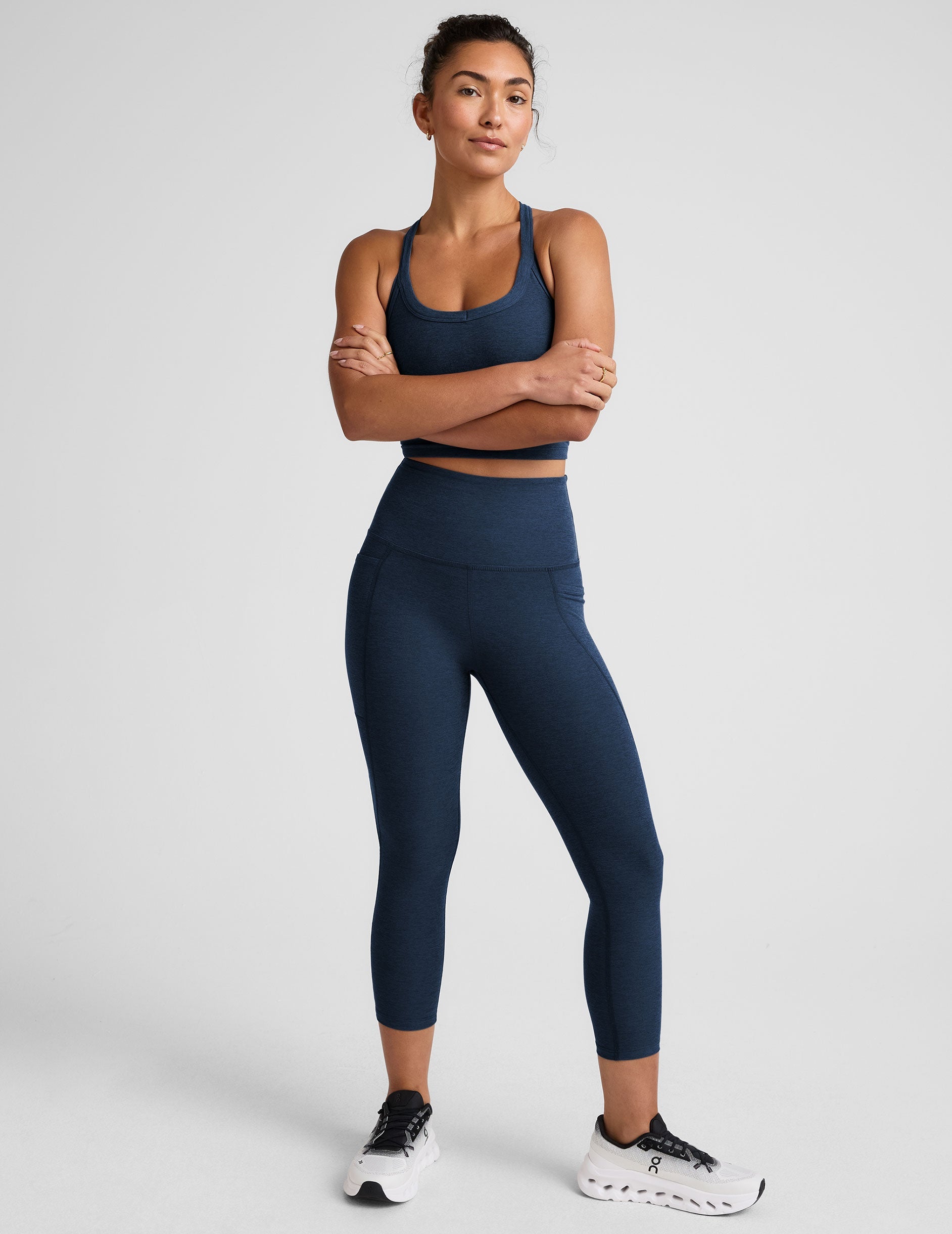 Woman wearing a navy athletic outfit on a light gray background