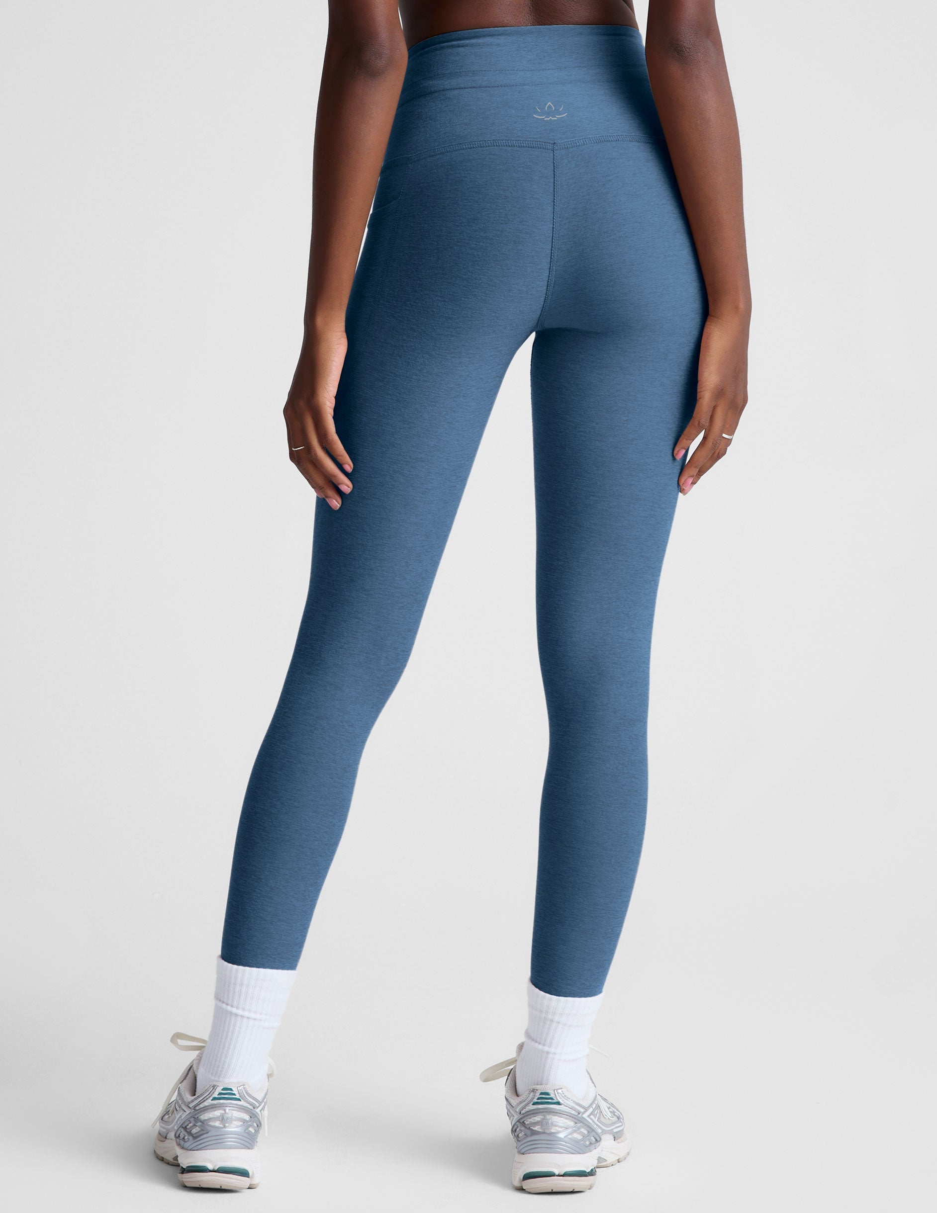 blue high-waisted midi leggings with pockets and a drawstring at waistband.