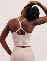 pink slim racerback cropped tank top and pink high-waisted midi leggings on a plain background.