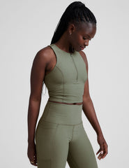 side image of a green racerback cropped tank with a half zip up detail in front.